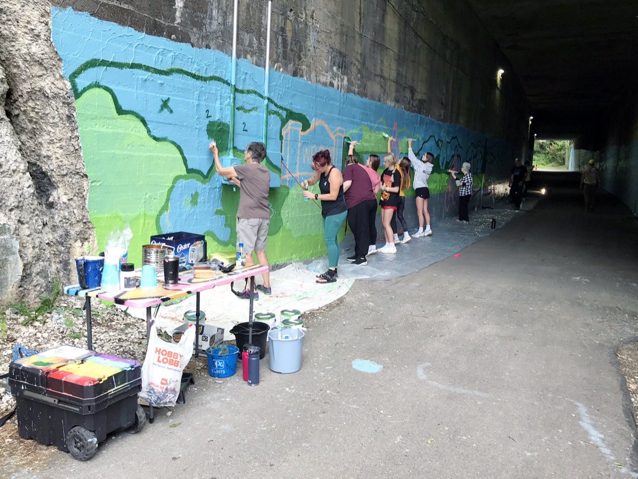 Volunteers painting the new tunnel mural on the Five Star Trail